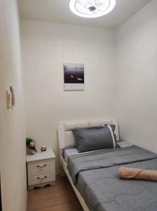 哥打京那巴鲁Thirteen Residence [TR06] @ ITCC Manhattan Suites的卧室配有一张床,墙上挂着一个钟