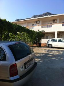 格拉达茨Apartments with a parking space Gradac, Makarska - 11332的停在大楼前停车场的汽车