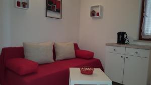 格拉达茨Apartment Gradac 11332d的客厅配有红色的沙发和桌子