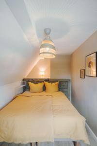 罗斯托克Stadthytte Ferienhaus的一间卧室配有一张带黄色枕头的大床