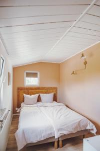 罗斯托克Stadthytte Ferienhaus的一间卧室配有一张带白色床单的大床