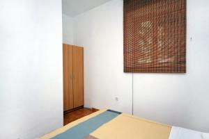 古维达里Apartment Pomena 10426b的一间卧室配有一张床和一个木制橱柜