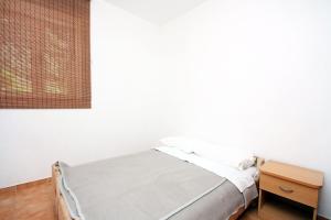 古维达里Apartments by the sea Pomena, Mljet - 10426的白色客房的一张床位,配有木桌