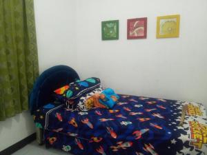 塔旺曼谷Argolawu Homestay的一间卧室配有一张带蓝色棉被的床