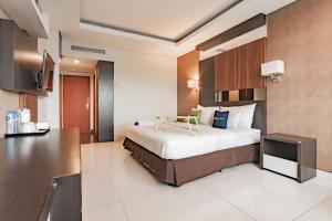 万隆Urbanview Hotel Newton Riau Bandung by RedDoorz的酒店客房,配有床和电视