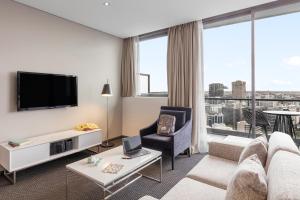 悉尼Meriton Suites Campbell Street, Sydney的带沙发和电视的客厅
