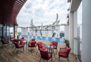胡志明市Muong Thanh Luxury Saigon Hotel的大楼内带桌椅的屋顶露台