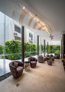 胡志明市Muong Thanh Luxury Saigon Hotel的带沙发和椅子的客厅以及窗户。