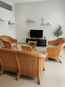 马六甲28 Residence Homestay的客厅配有沙发、椅子和电视