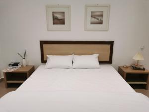 马六甲28 Residence Homestay的卧室配有一张带两张桌子的大型白色床