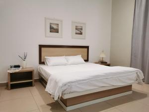 马六甲28 Residence Homestay的一间卧室配有一张带白色床单的大床