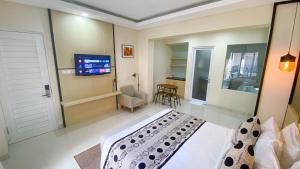 登巴萨Ultimate Residence Bali的一间卧室配有一张床和一台平面电视