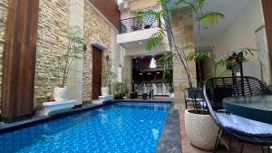 登巴萨Ultimate Residence Bali的一座带桌椅的别墅内的游泳池