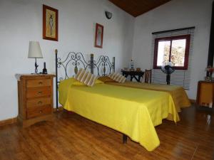 IsoraCasa Goliath的一间卧室配有一张黄色床罩的床