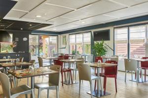 马克思维尔Kyriad Nancy Ouest - Laxou的餐厅设有桌椅和窗户。