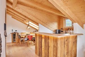 加尔米施-帕滕基兴Chalet Sunshine的带木制柜台的厨房(位于带木制天花板的客房内)