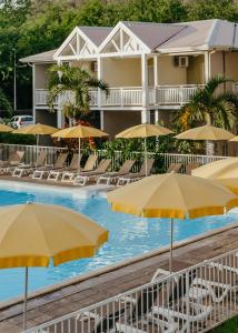 圣吉尔莱班留尼汪岛星礁度假村的酒店前方的游泳池配有椅子和遮阳伞