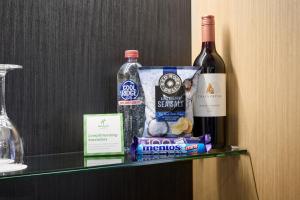 珀斯珀斯城市中心假日酒店的摆放着一瓶葡萄酒和一袋小吃的架子