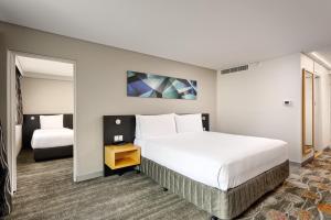 珀斯珀斯城市中心假日酒店的酒店客房设有一张白色大床和一张桌子。