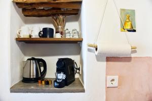 RalakiGiourgas Cottage Milos Island的墙上的架子上的咖啡壶