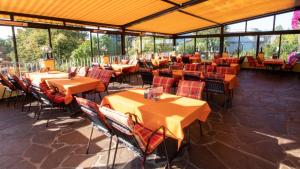 因斯布鲁克阿尔皮纳咖啡酒店的餐厅设有橙色桌椅和窗户。