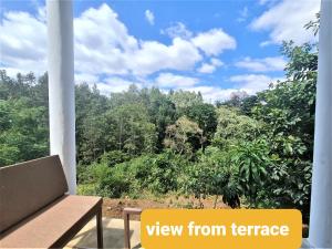 阿鲁沙Holiday cottage by the river, Arusha的以及享有树木景致的阳台。