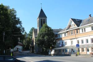 马尔梅迪Au lit de l'Amblève的一座教堂,塔楼在建筑物旁边的街道上