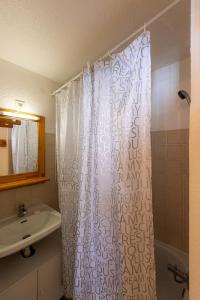 雷阿隆Appartement Chabrières的浴室配有淋浴帘和盥洗盆。