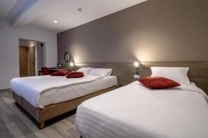布拉索夫VMD Residence的一间卧室配有两张带红色枕头的床