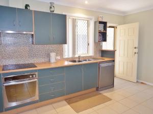 西南岩Village Centre 3 South West Rocks的厨房配有蓝色橱柜和水槽