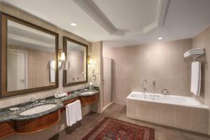 巴库巴库凯悦酒店的浴室配有2个盥洗盆、浴缸和大镜子