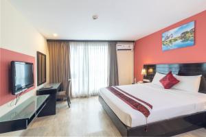 曼谷波仕套房酒店的一间酒店客房,配有一张大床和一台平面电视