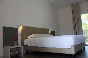 卡斯蒂里昂纳·德拉佩Tennis Rocchette Resort的卧室设有一张白色大床和一扇窗户。