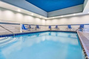 南本德La Quinta Inn & Suites by Wyndham South Bend near Notre Dame的大楼内带蓝色椅子的游泳池