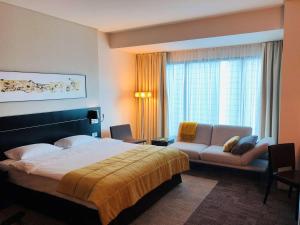 波兹南Andersia Hotel & Spa Poznan, a member of Radisson Individuals的酒店客房,配有床和沙发