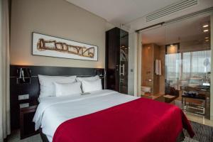 波兹南Andersia Hotel & Spa Poznan, a member of Radisson Individuals的一间卧室配有一张带红色毯子的大床
