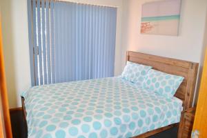 西南岩Seaview Townhouse 3的一间卧室配有一张带蓝色和白色棉被的床