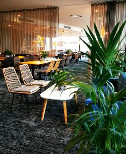 卡迪夫加的夫湾未来旅馆的一间设有桌椅的餐厅,种植了植物