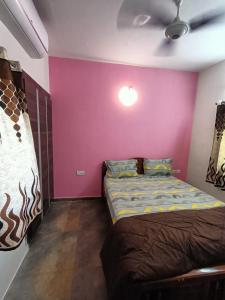 钦奈Coral Drive Villas -Your Private Beach Destination的一间卧室配有一张床和紫色的墙壁