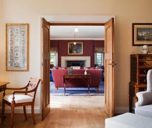 基洛格林Ard na Sidhe Country House Hotel的客厅配有沙发和桌子