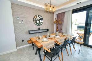 凯麦尔Yedisu Villaları Family Only的一间带桌椅和时钟的用餐室