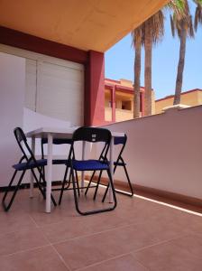 Parque HolandesCasa Guira - Fuerteventura的棕榈树庭院内的两把椅子和一张桌子