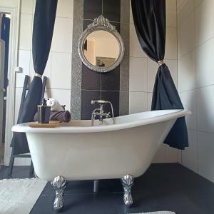 卡尔卡松Entre Bastide et Cité的浴室设有白色浴缸及镜子