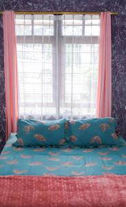 Citeureup 1Vila murah di dekat kawasan wisata lembang的一张带两个蓝色枕头的床和窗户