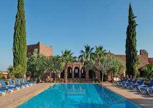 泰赫瑙特卡斯巴安古尔酒店的度假村的游泳池,带椅子和树木