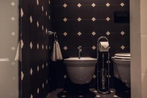 博尔扎诺Loom的一间带卫生间的浴室以及黑色和白色的瓷砖墙。