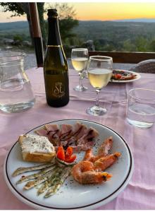 KozljakSkalameri的一张桌子,上面放着一盘食物和一瓶葡萄酒