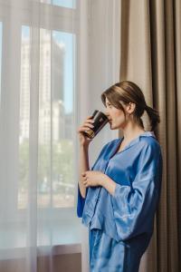 华沙波洛尼亚宫大酒店的穿着蓝色衣服的女人在手机上讲话