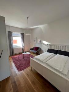 曼海姆Feel-Good Apartment In Mannheim-Neckarau的卧室配有白色的床和红色地毯。