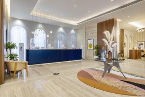 多哈voco Doha West Bay Suites, an IHG Hotel的大堂设有桌子和蓝色的墙壁